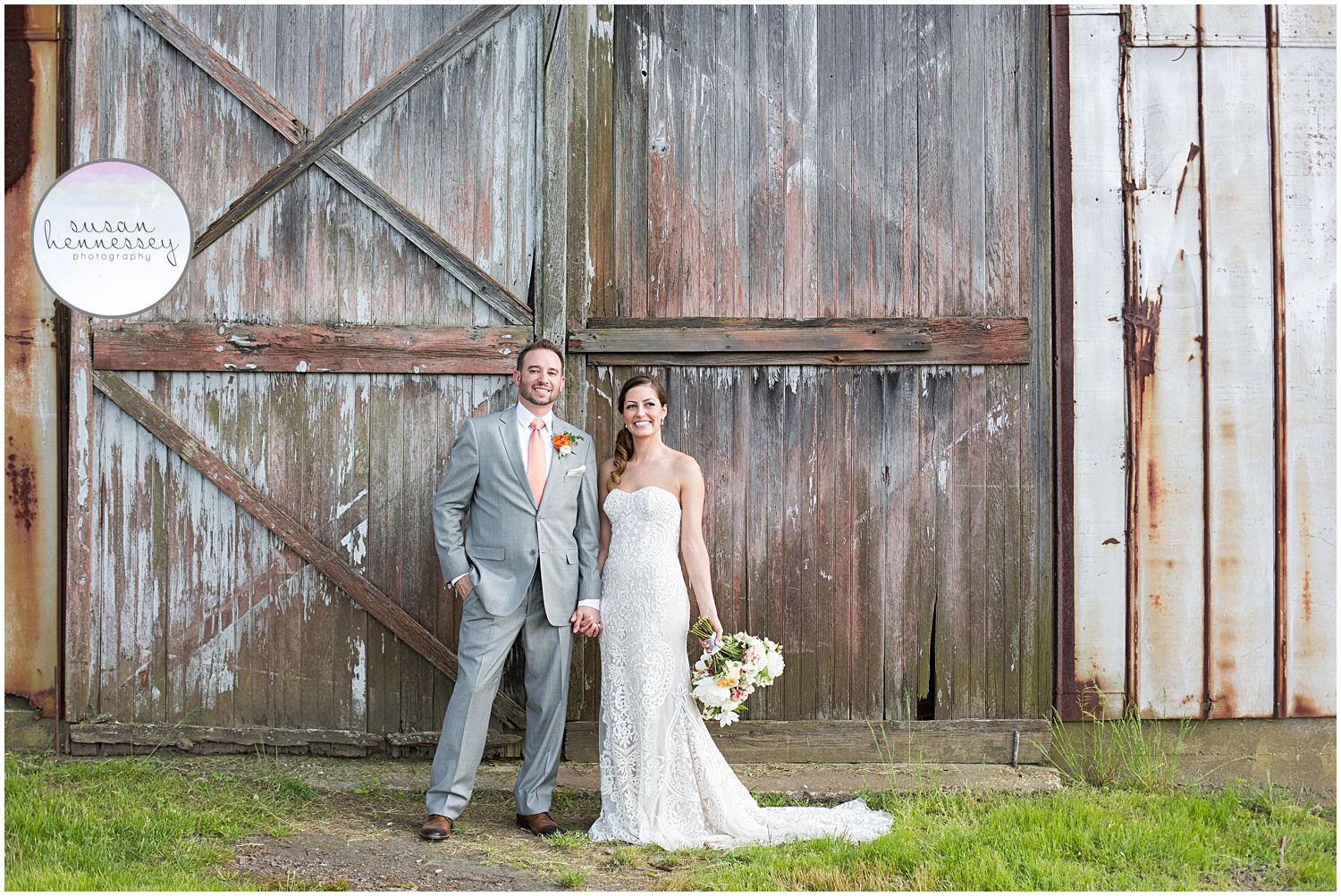 Couple posing in front of barn