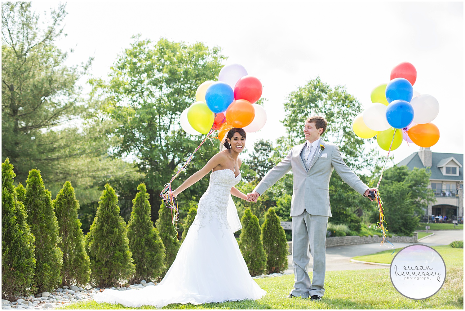Happy couple pose with colorful balloons on their wedding day.