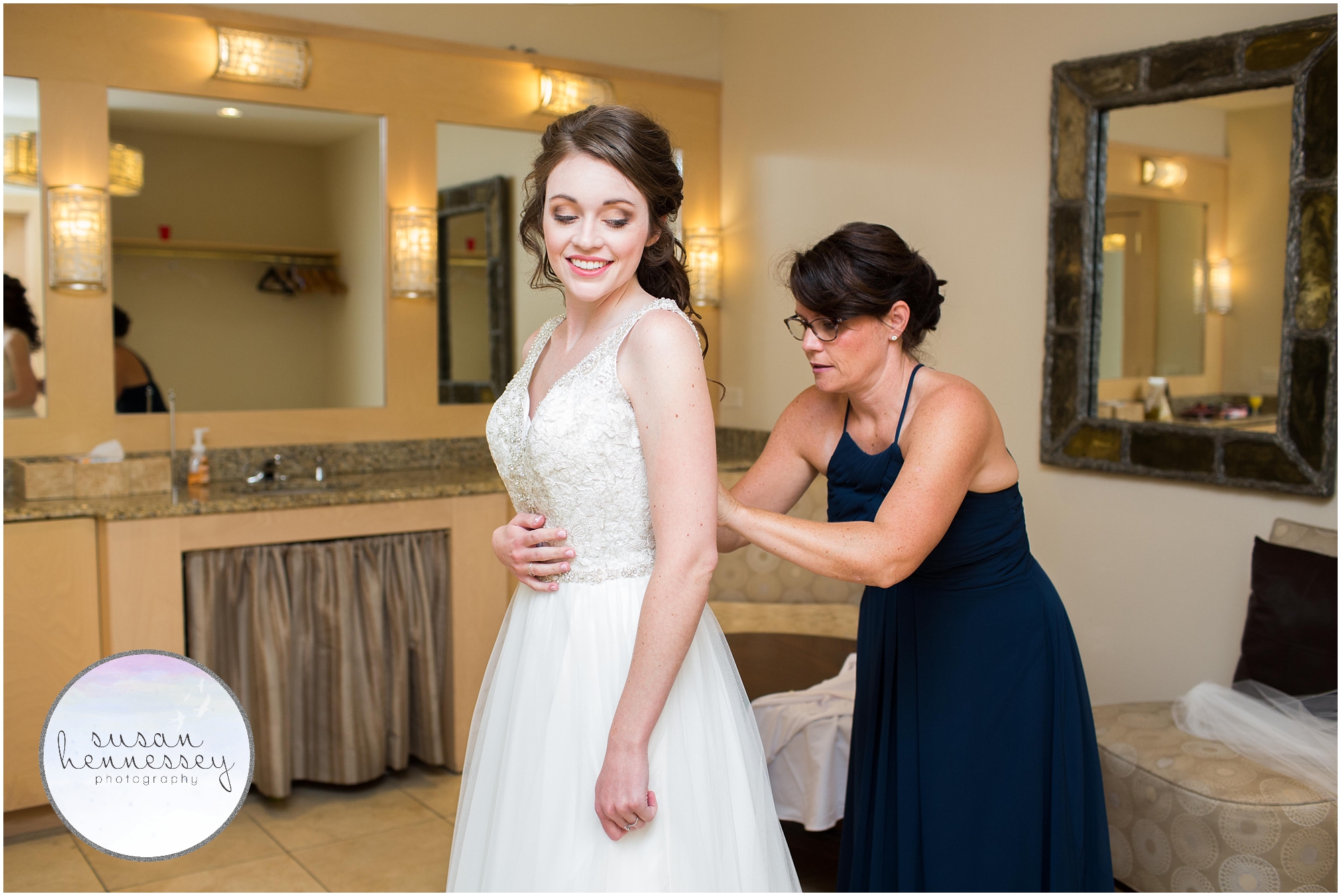 bride being zipped into her dress on her wedding day
