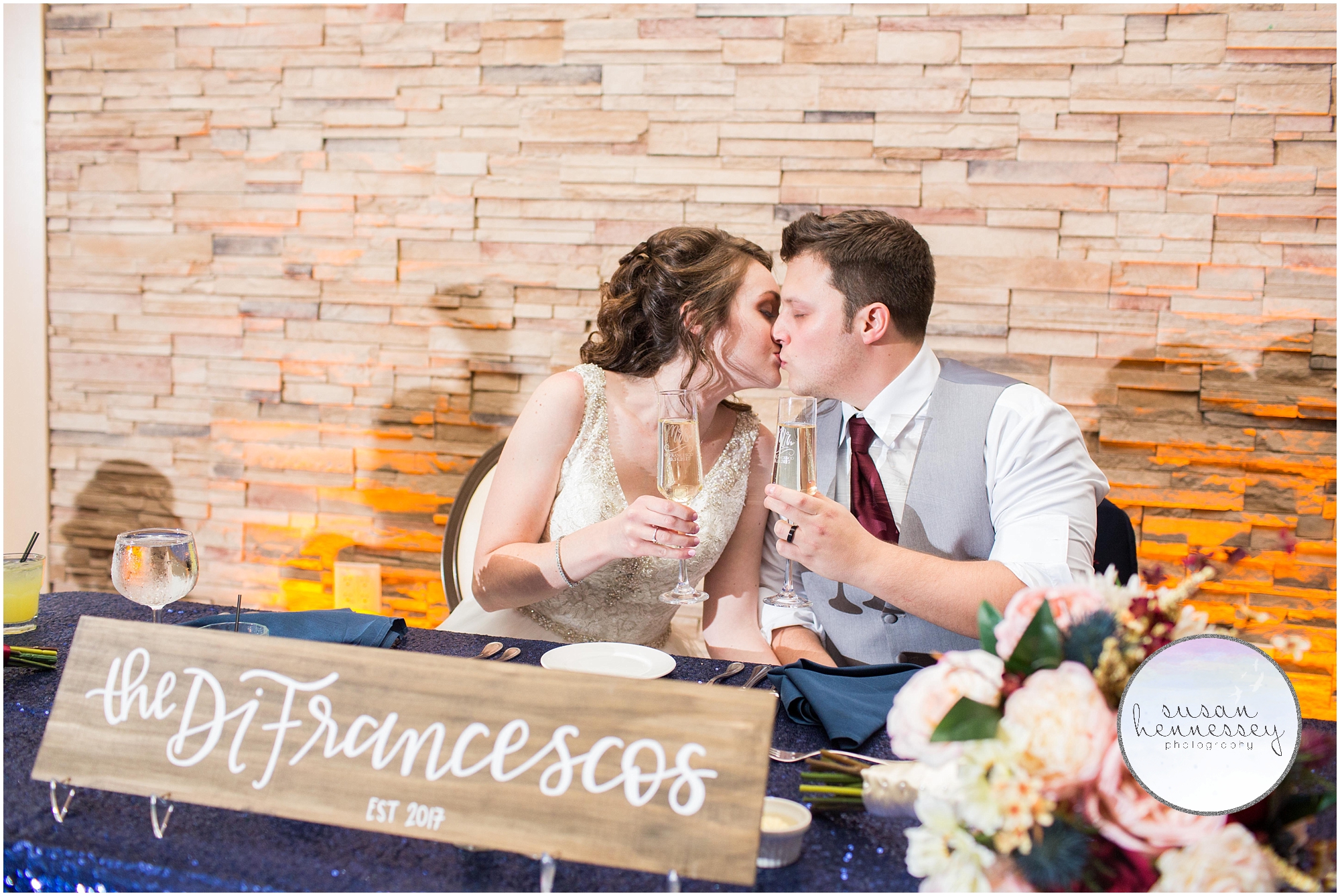 couple kisses while holding champagne 