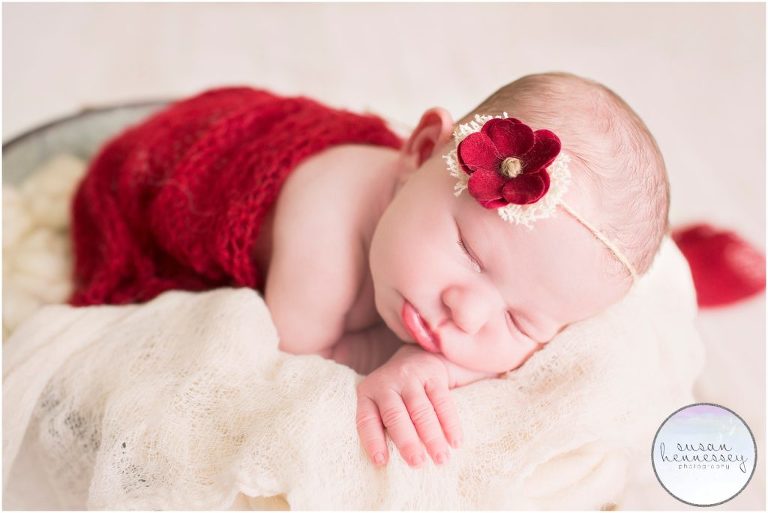 Posed newborn session in studio with pops of red. 