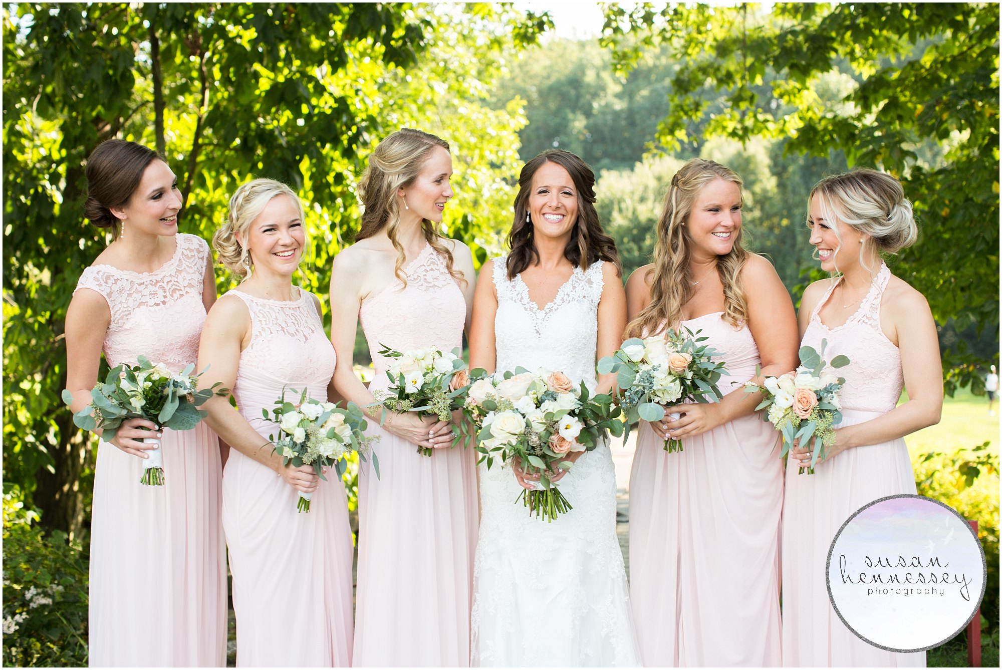 Bridesmaids in pale pink laugh at Old York Country Club wedding