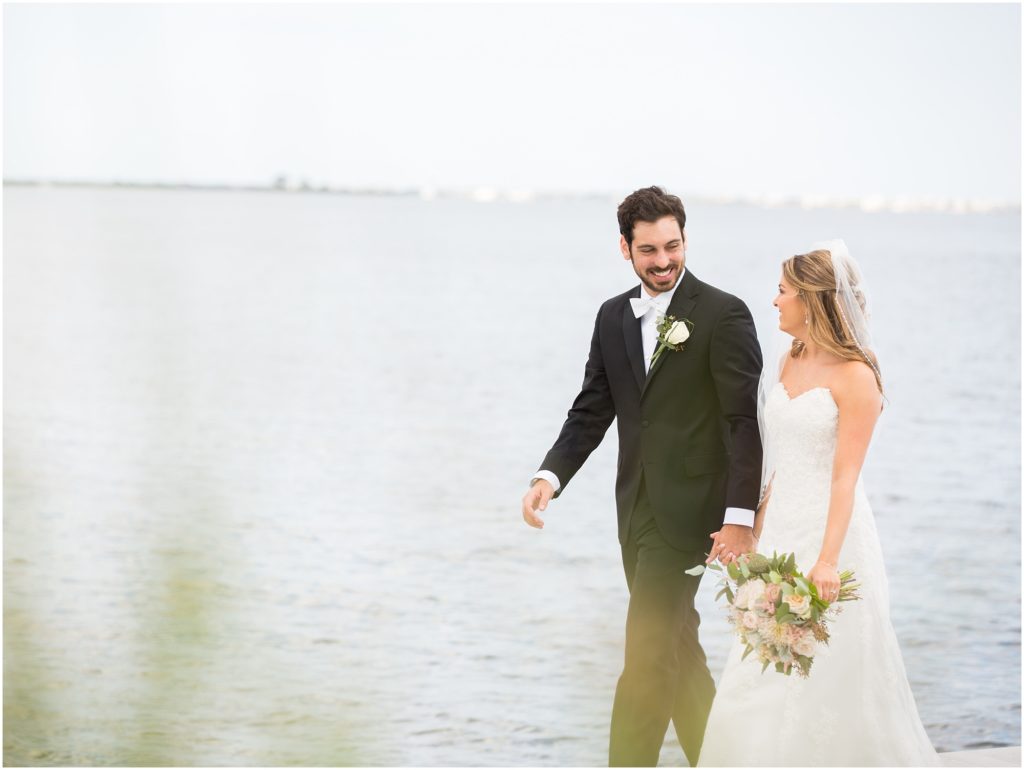 Bride and groom walk together on the dock at Mallard Island.