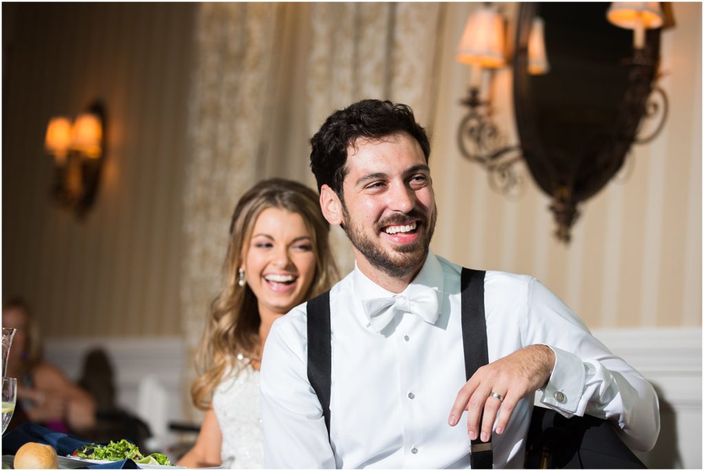 Bride and groom laugh during speeches at their Mallard Island Yacht Club wedding
