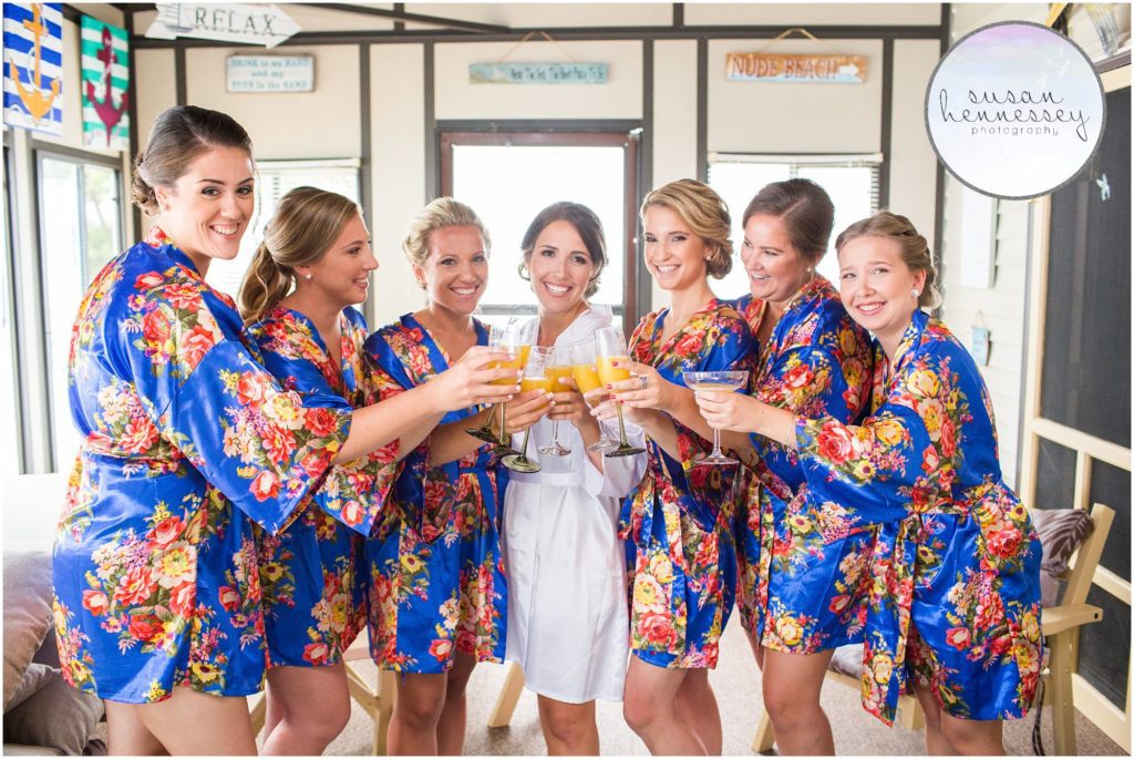 Bridesmaids drink mimosas on the wedding day in matching blue floral robes
