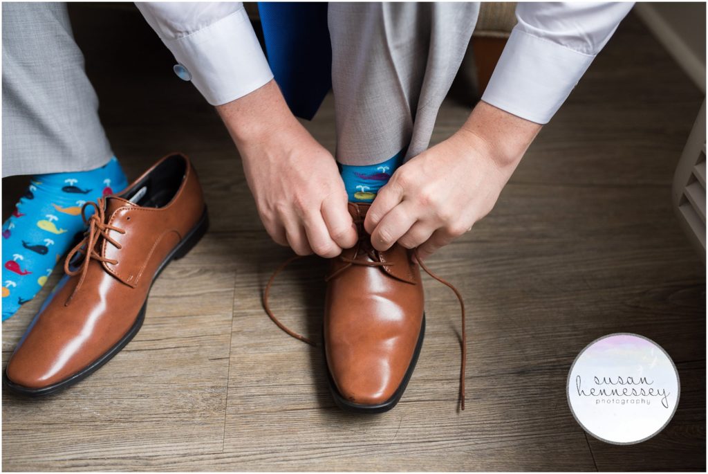 Groom ties his shoes on the day of his Cape May wedding.