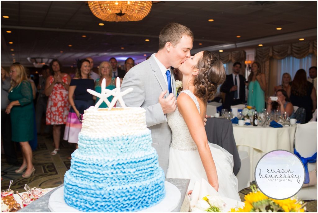 Bride and groom kiss after cutting their wedding cake.