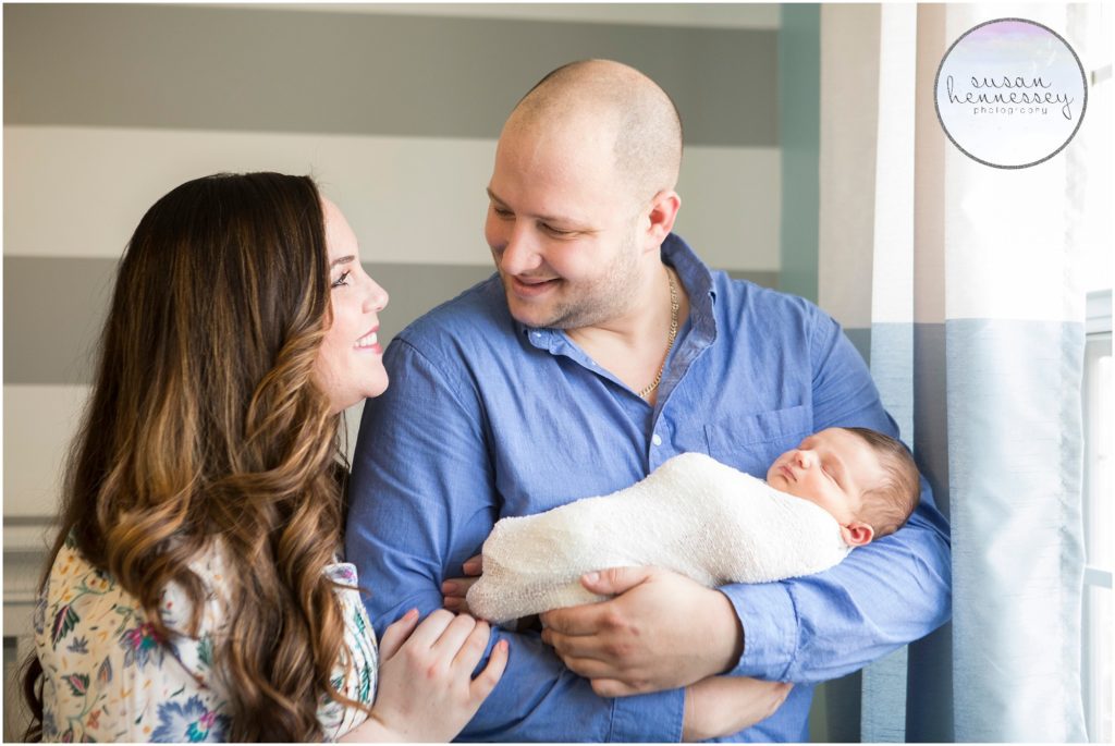 Parents hold newborn baby during his newborn session