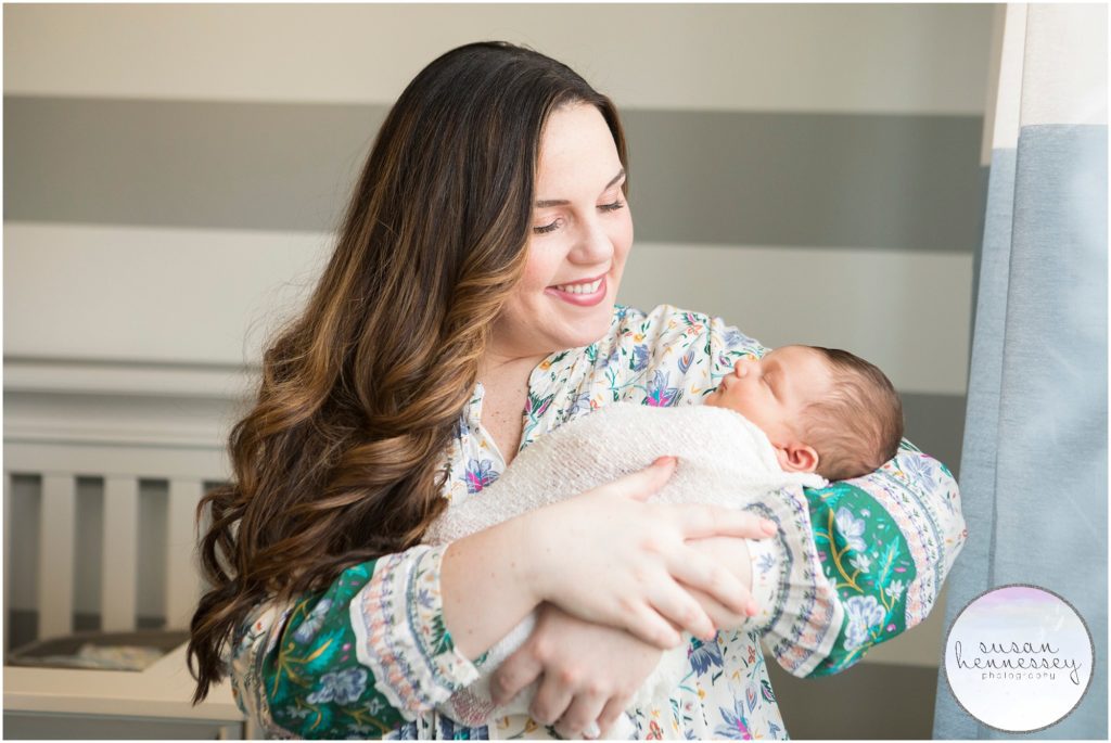 Happy mother holds newborn during his newborn photo session