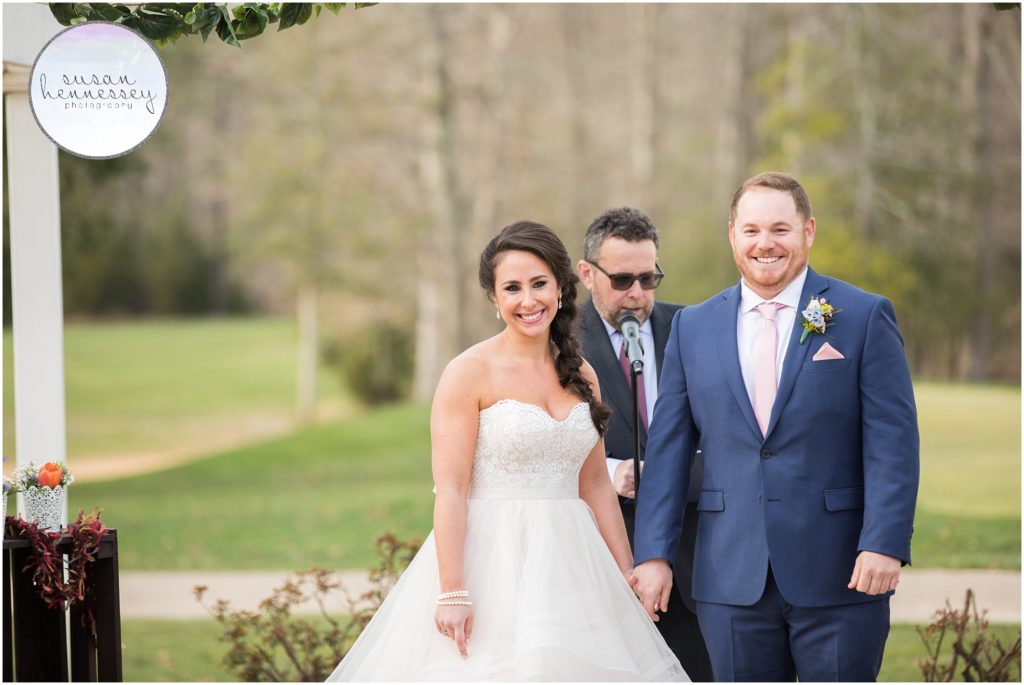 Bride and groom smile at Ceremony at Running Deer Golf Club