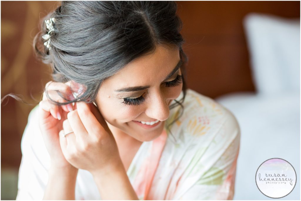 Happt bride puts on earrings groom gifted her on their wedding day