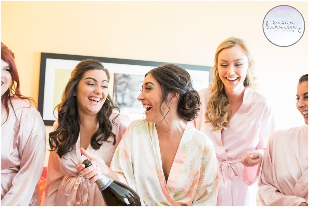Bride and Bridesmaids in floral robes pop champagne