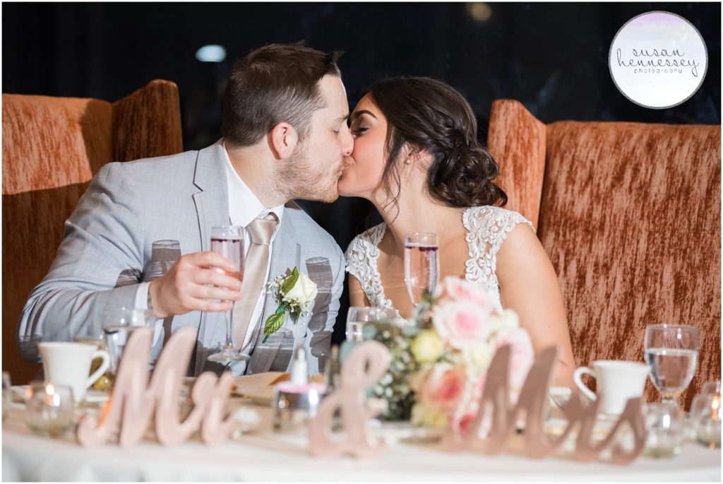 Bride and groom kiss at the sweetheart table.