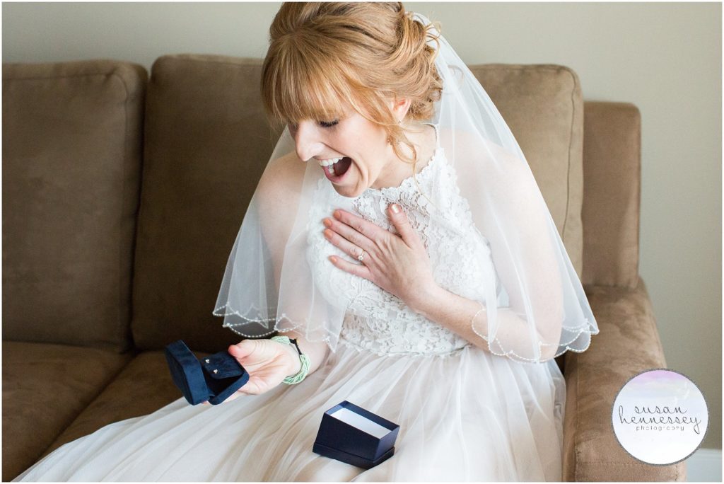 Bride happily reacts to groom's wedding day gift. 