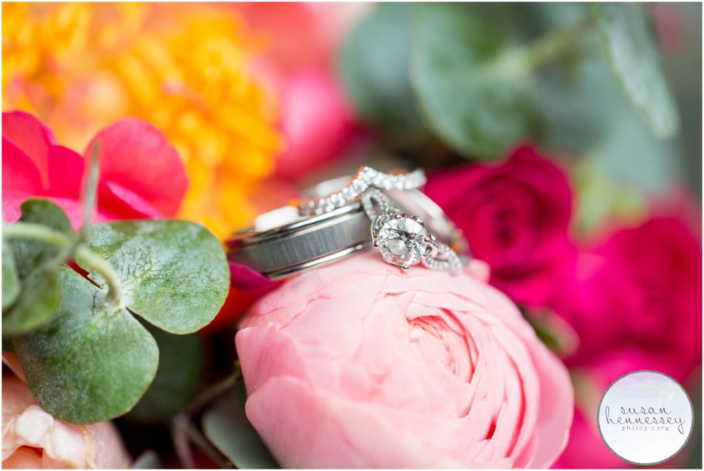 Wedding bands and engagement ring on bouquet.