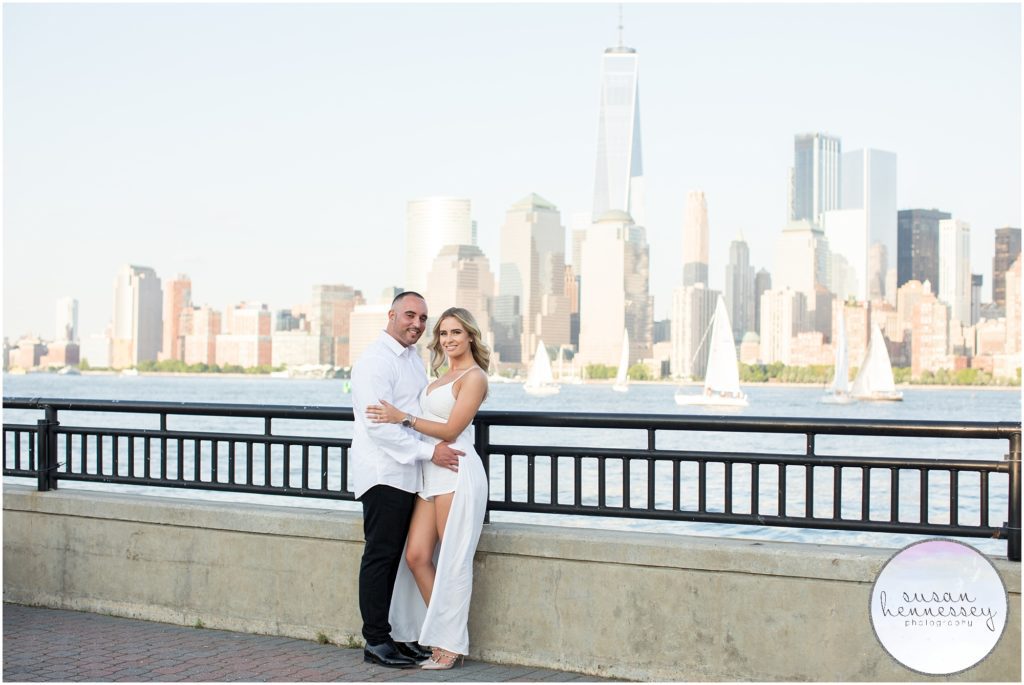 Engagement session with couple posing in front of the new york city skyline.