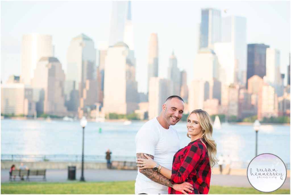 Jersey City Engagement session with couple posing in front of the new york city skyline.