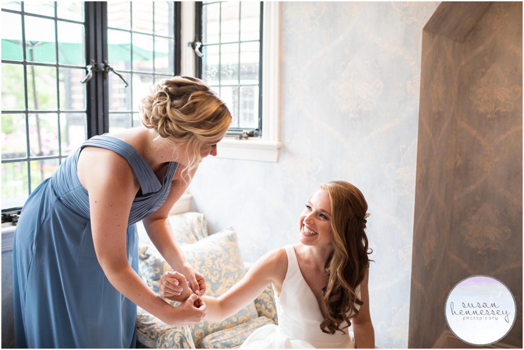Maid of honor helps bride with her bracelet 