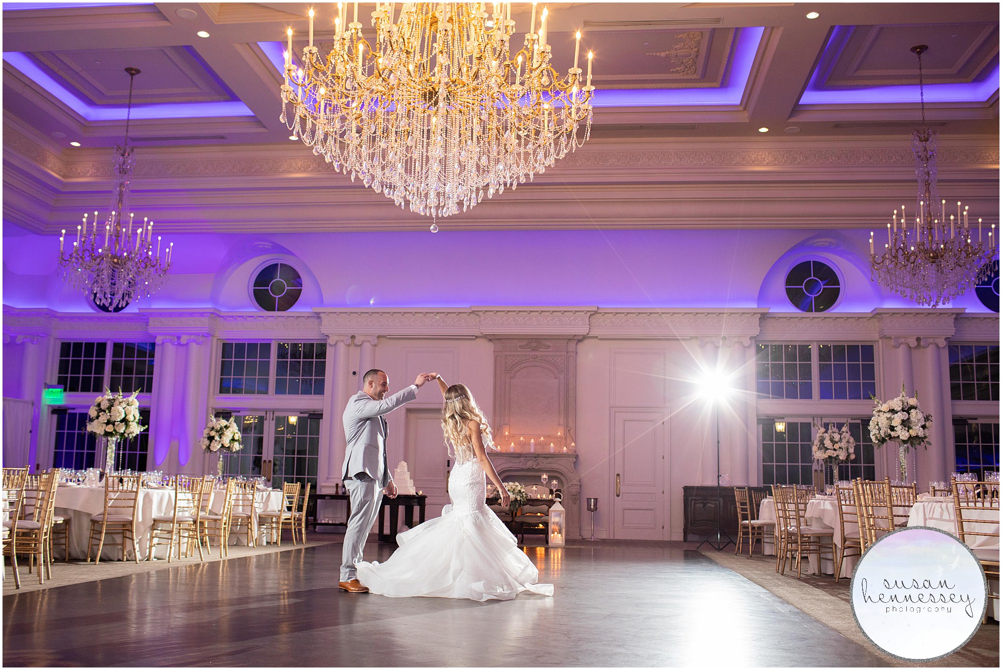 Groom twirls bride on dance floor.
