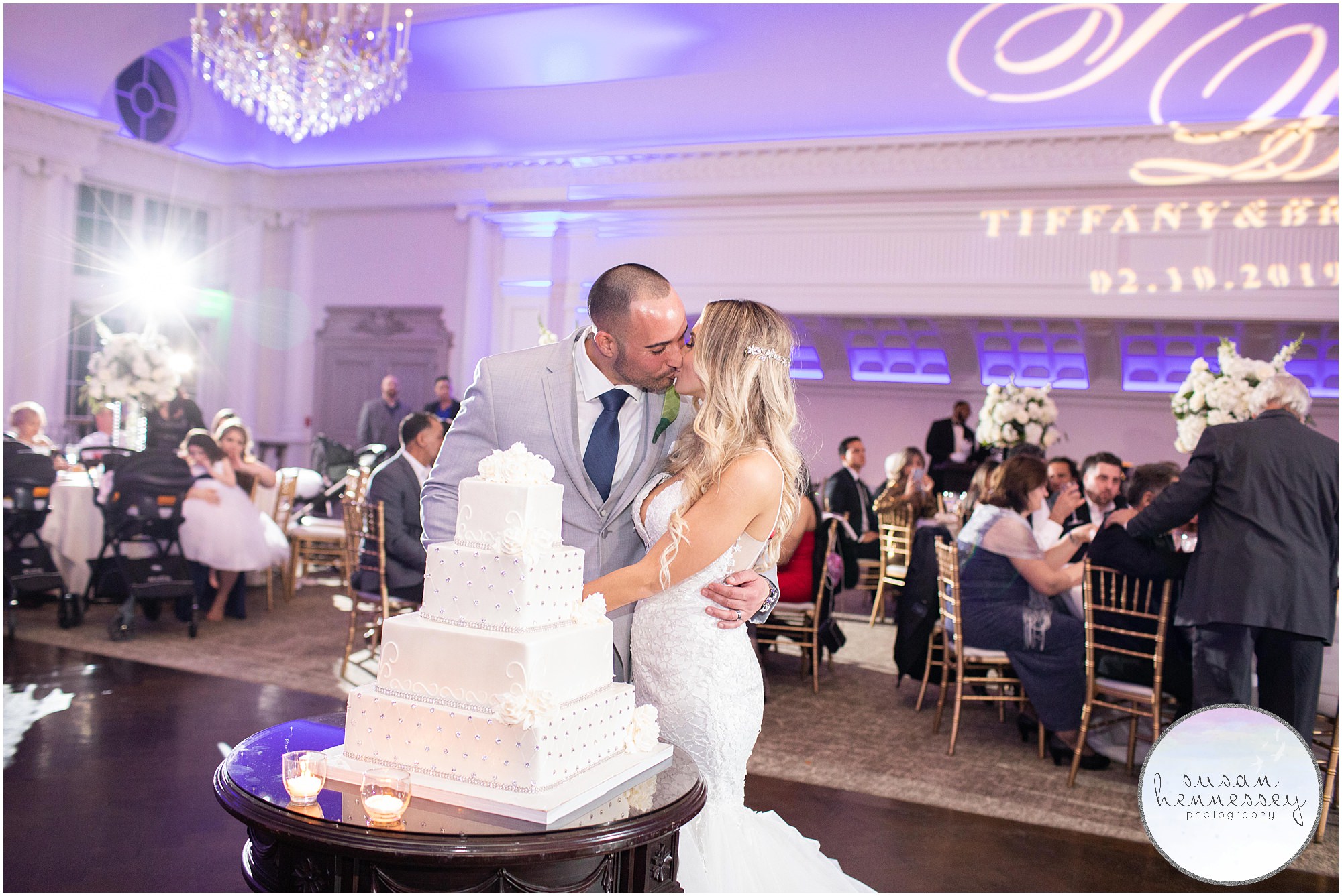 A bride and groom share a kiss after cutting their wedding cake.