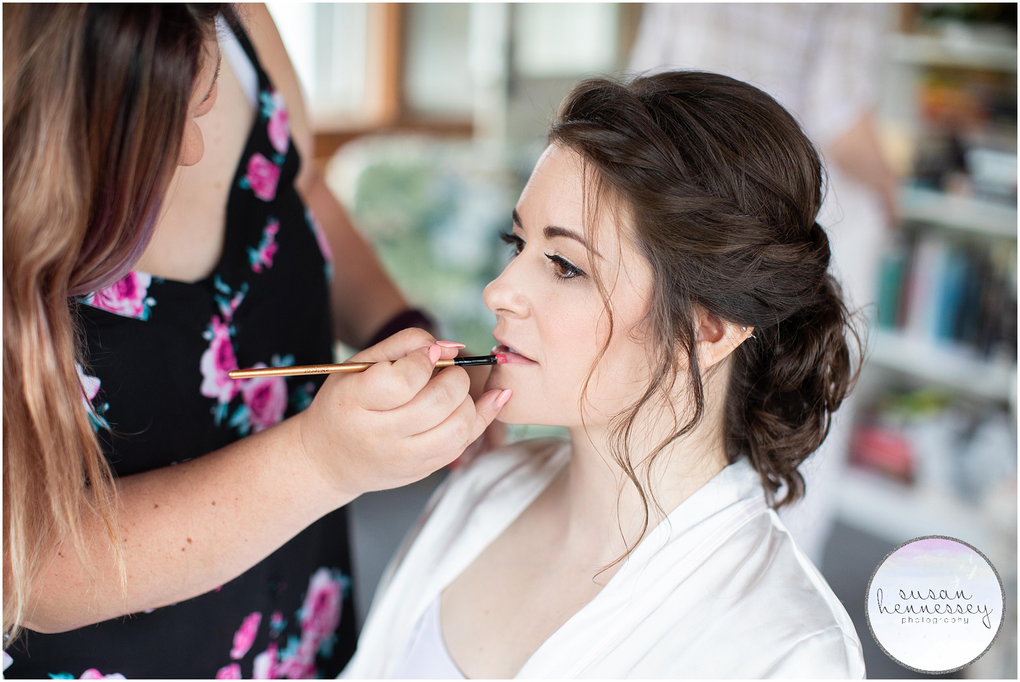 Bride receives final makeup on her wedding day. 