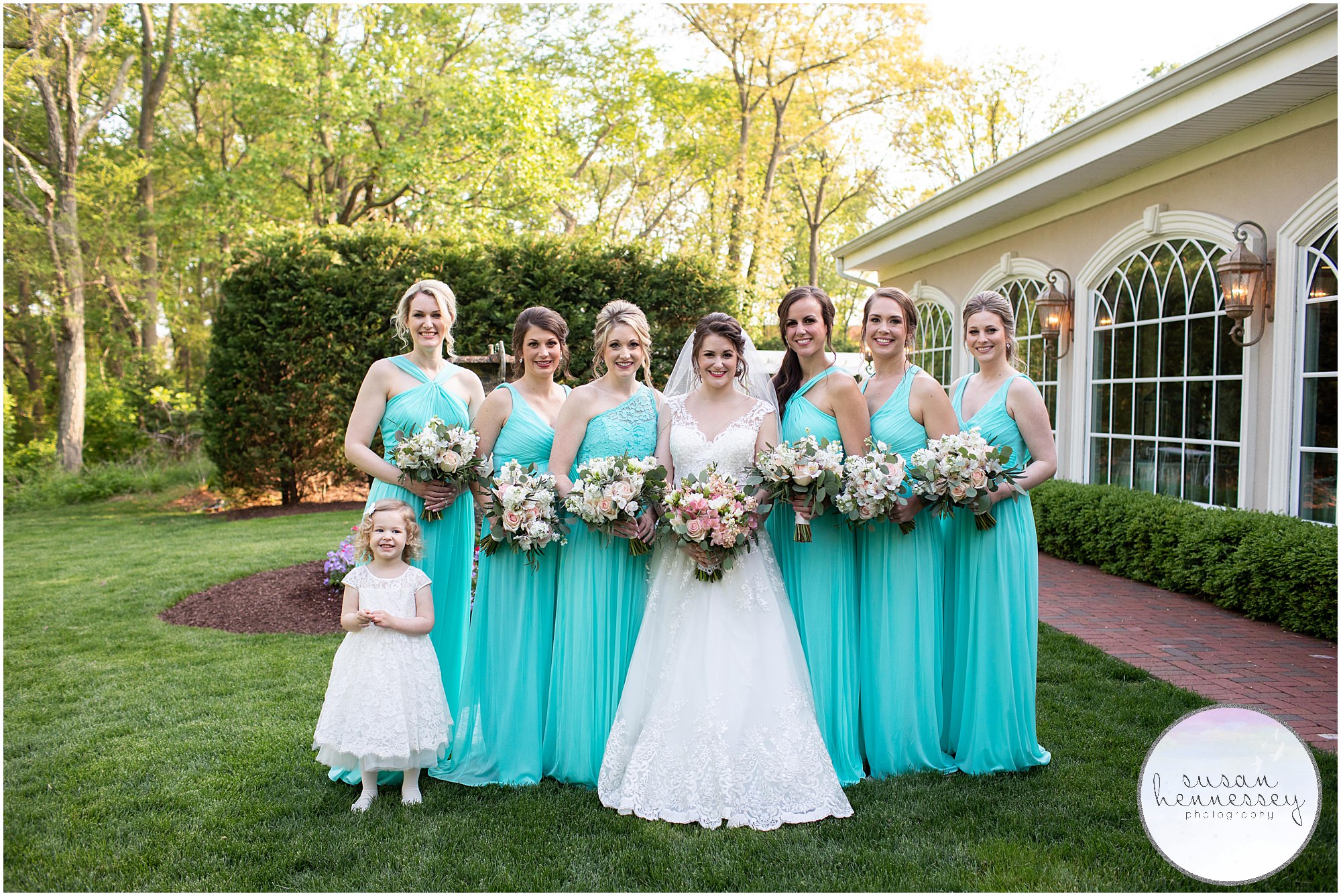 A bride, bridesmaids and flower girl dressed in David's Bridal gowns.