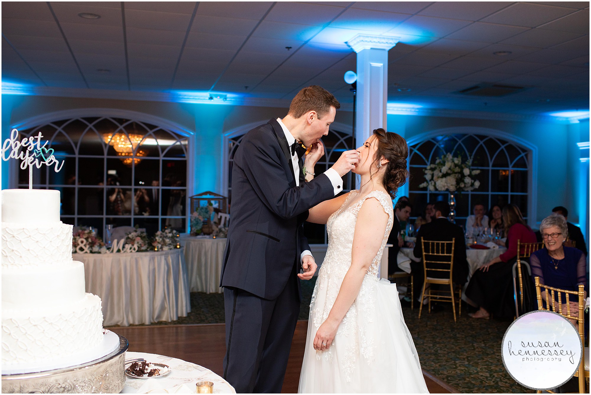 Bride and groom feed each other cake at their wedding reception. 