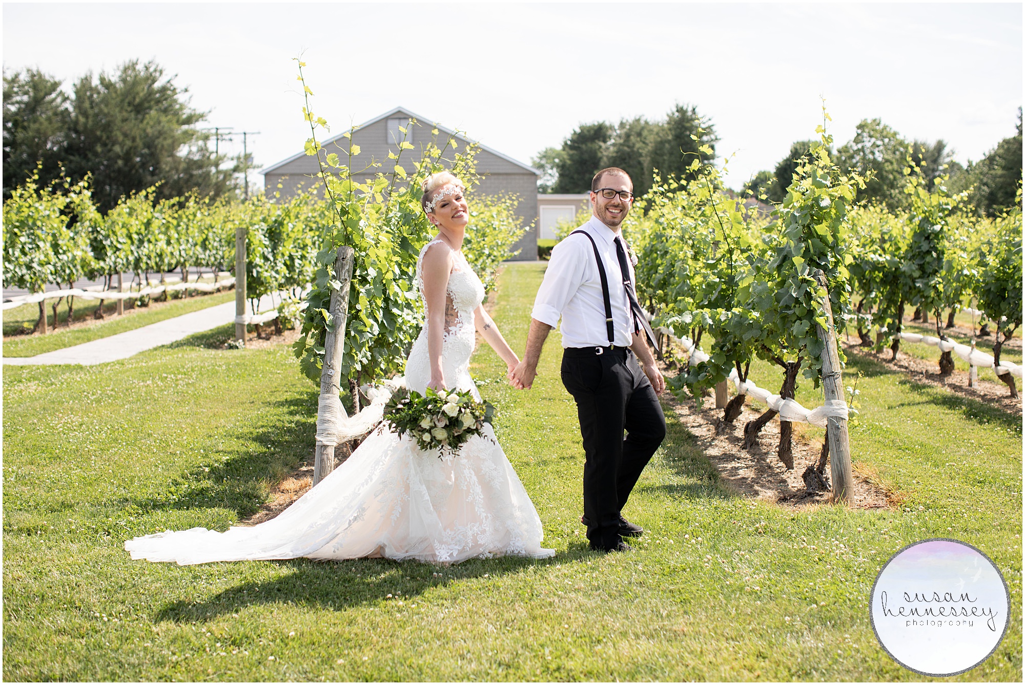 A bride and groom walking in the vineyards