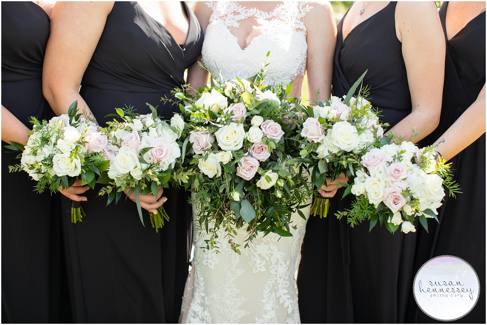 Detail of bridesmaids in black dresses and their bouquets.