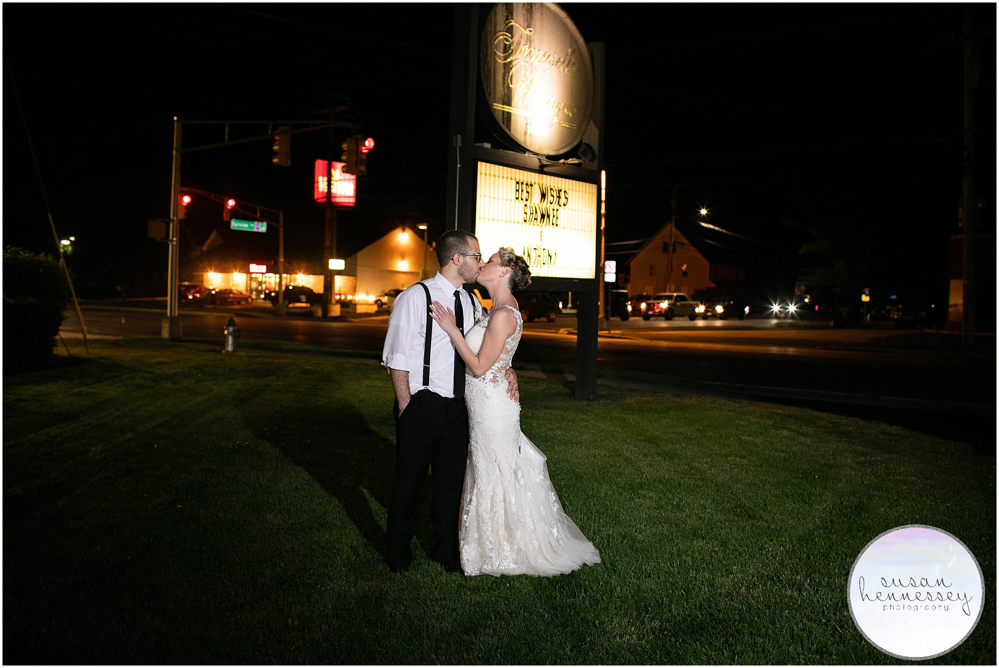 bride and groom kiss in front of venue 