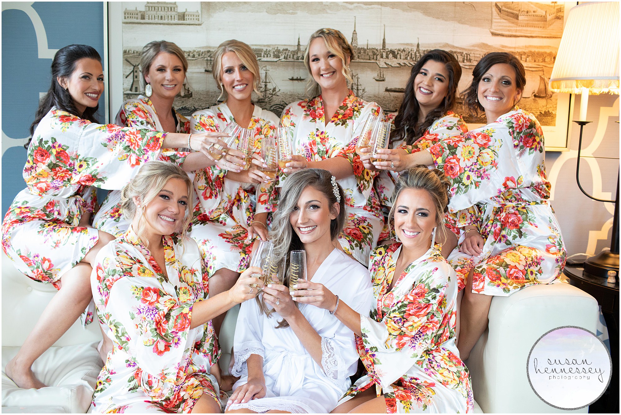 Bride and bridesmaids in floral robes with champagne at Hotel Monaco in Philadelphia.