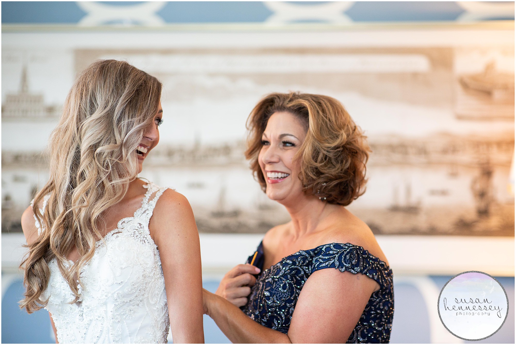 Mother of the bride helps bride into her wedding gown for Union Trust wedding.