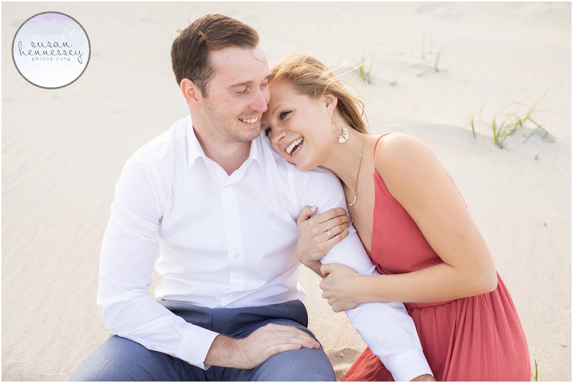 An engaged couple laughs at their LBI engagement session. 