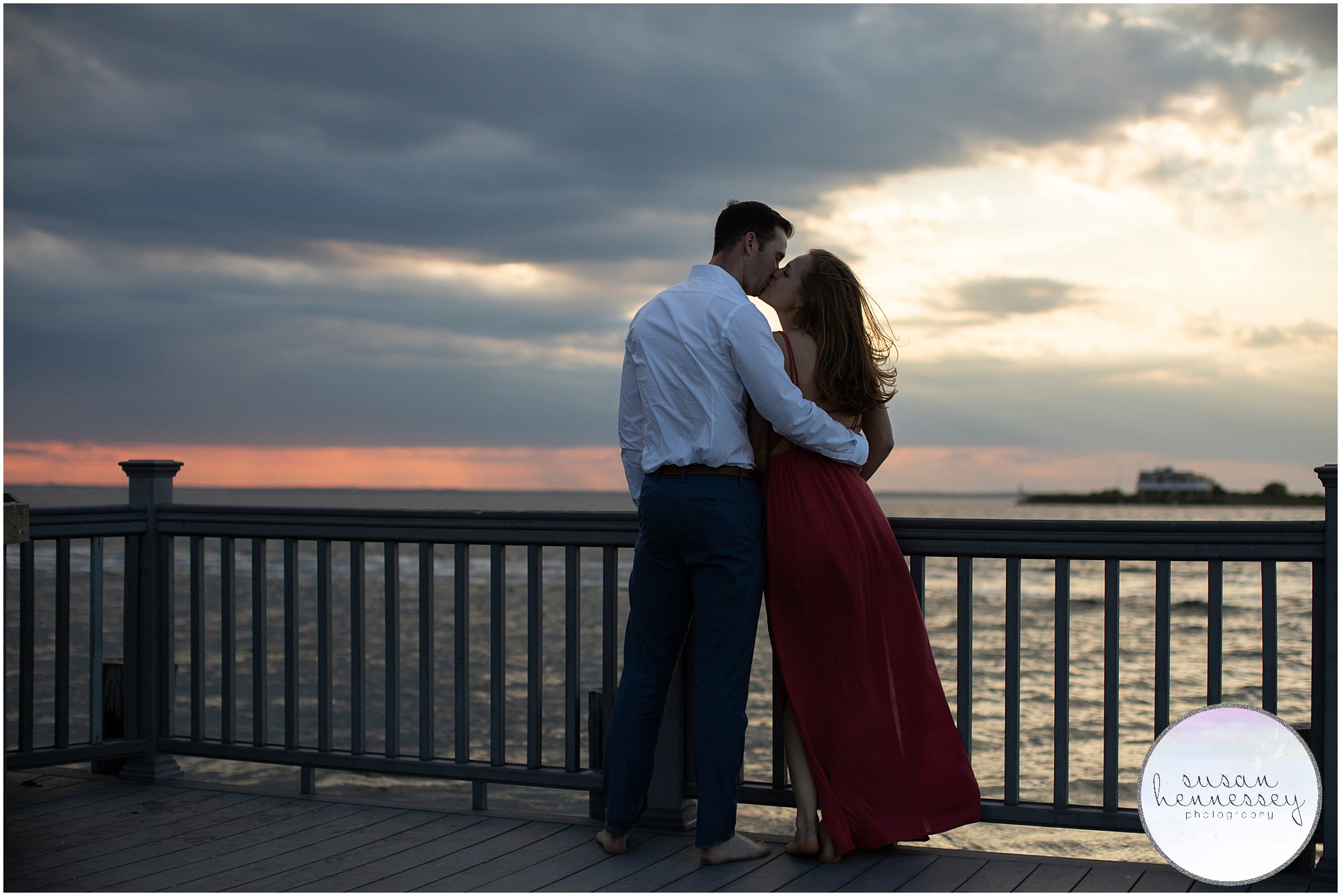 An engaged couple kiss at their sunset engagement photography session. 