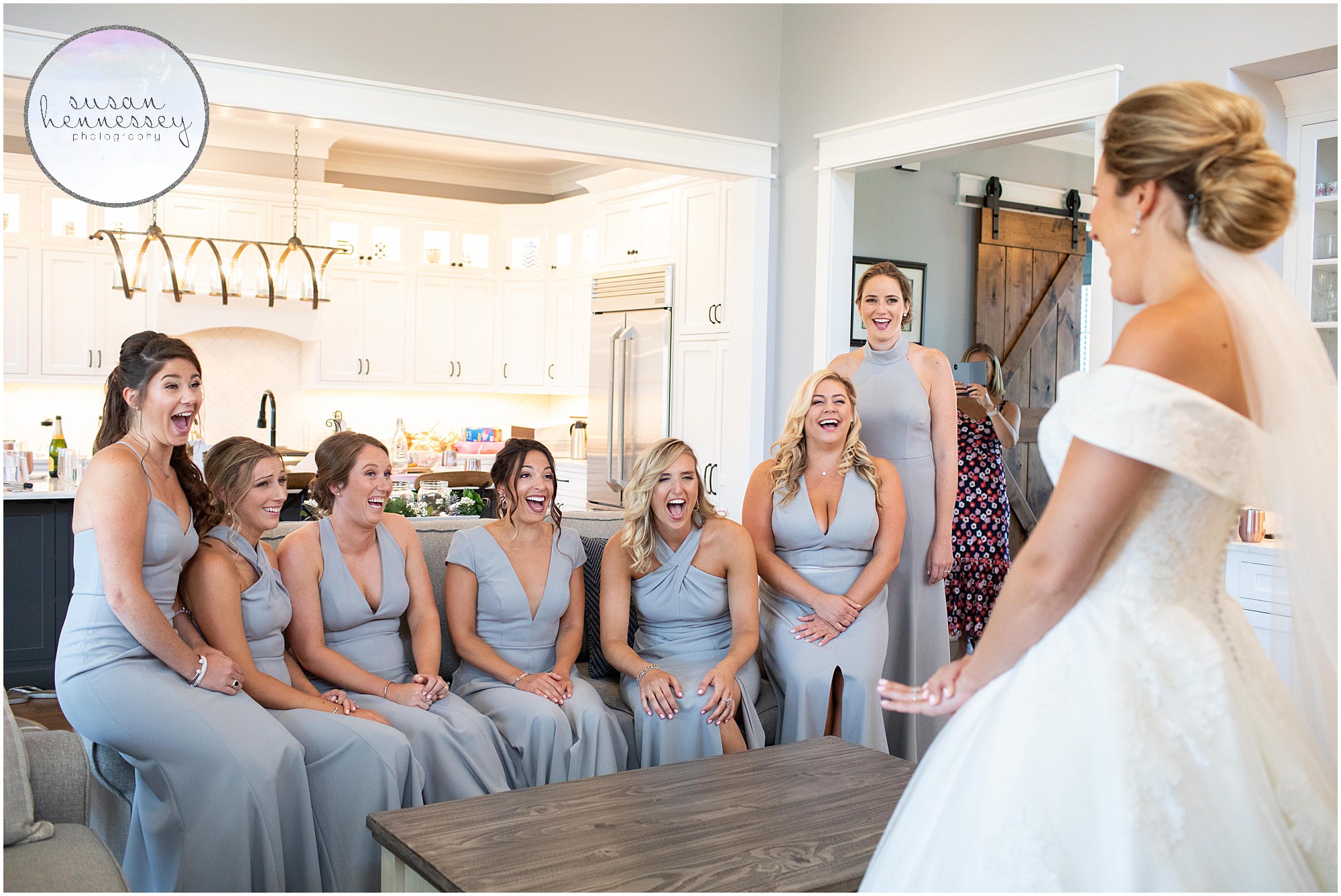 Bride has first look with bridesmaids in gray.