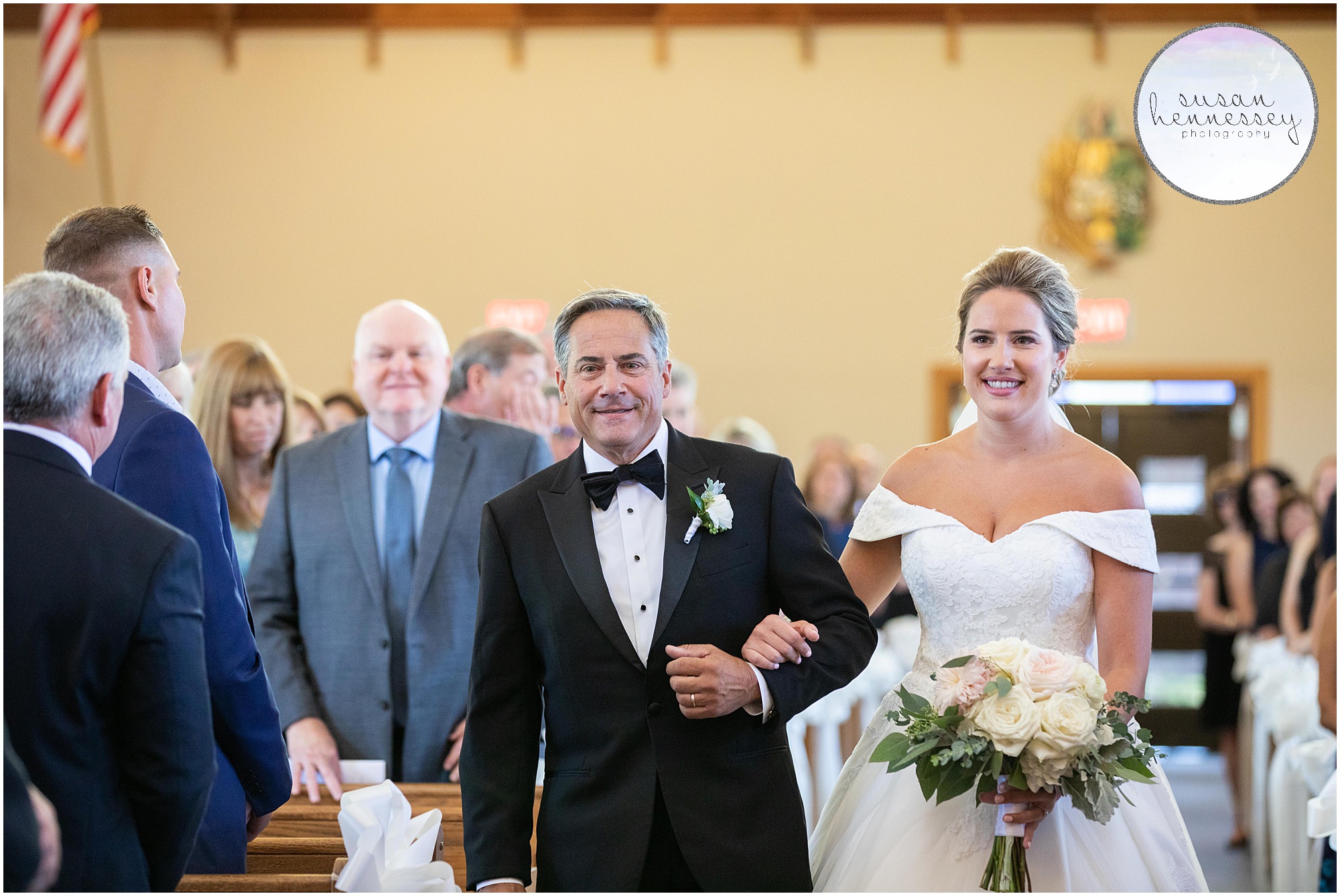 The bride's father escorts her down the aisle at her Catholic ceremony