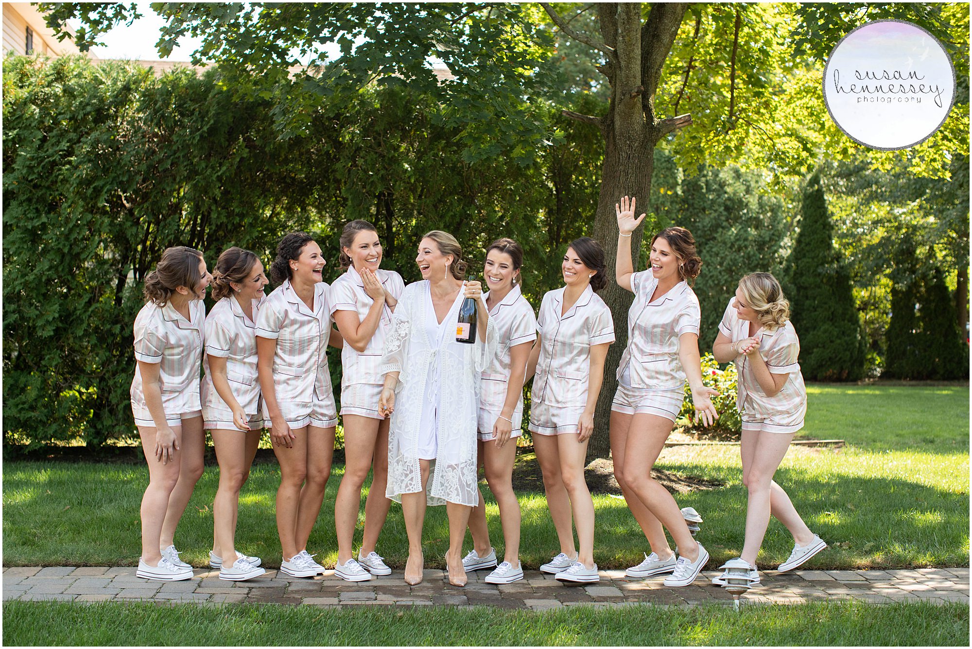 Bride and bridesmaids pop champagne in matching pajamas.