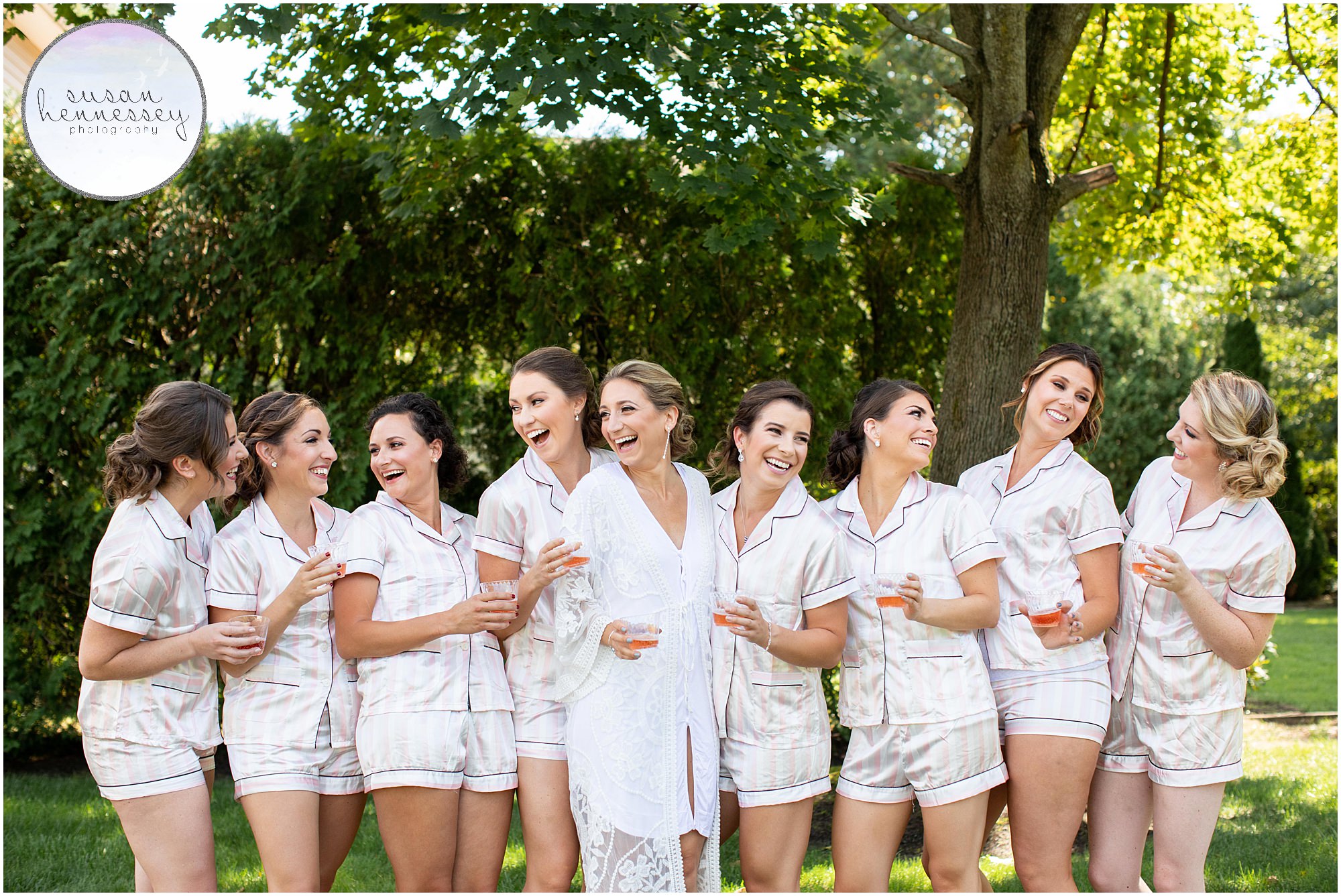 Bride and bridesmaids drink champagne in matching pajamas.