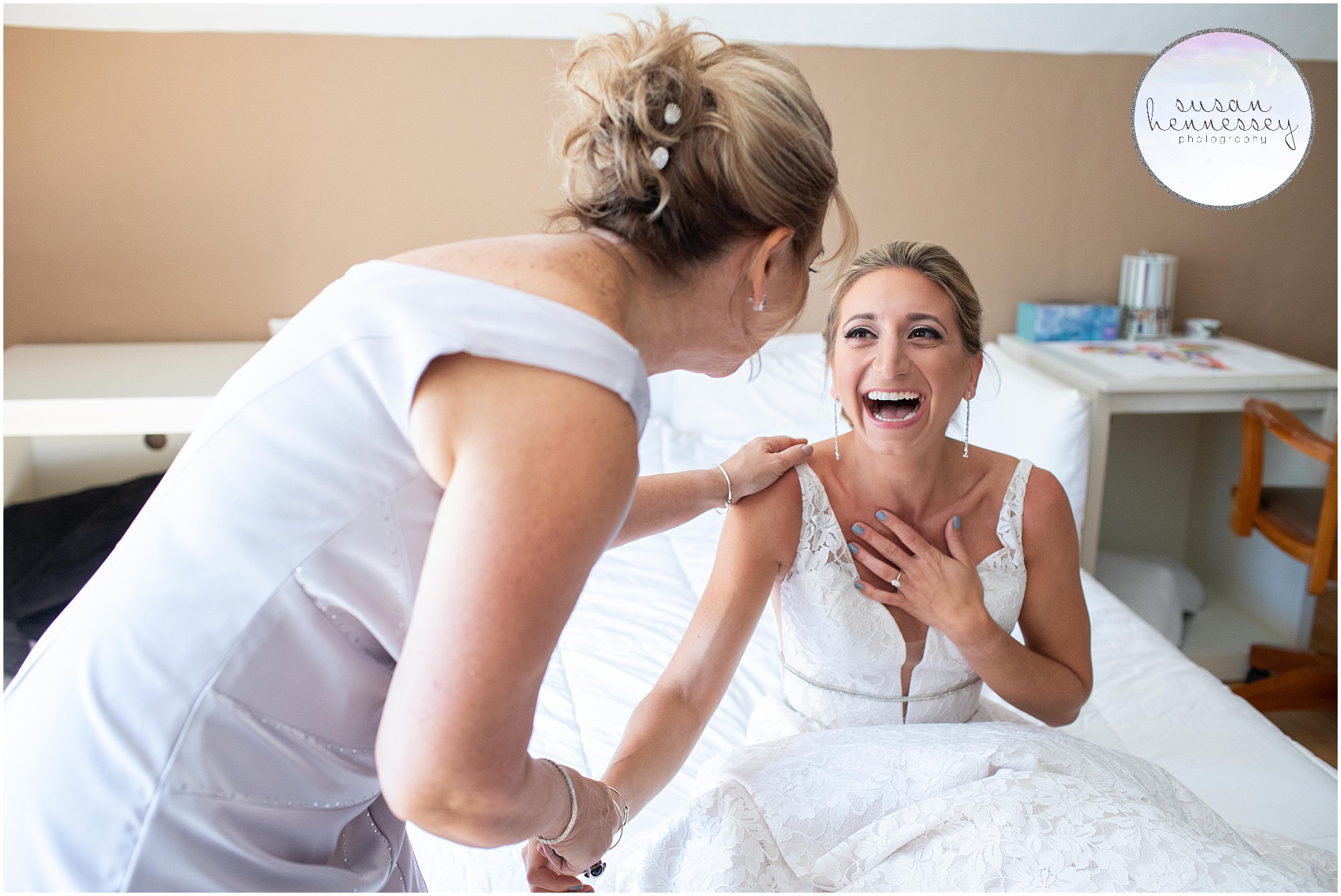 A bride and her mother have a happy laugh on her wedding day