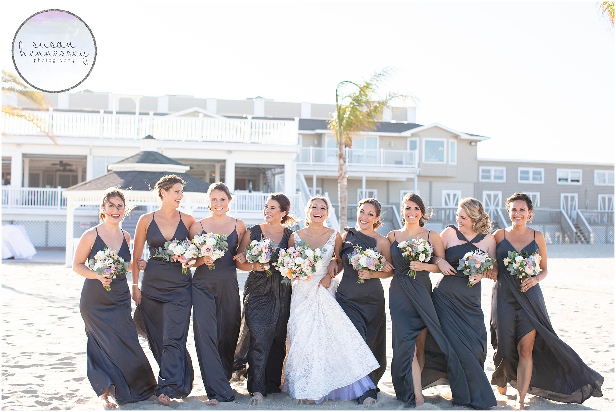 Bride and bridesmaids laugh on the beach