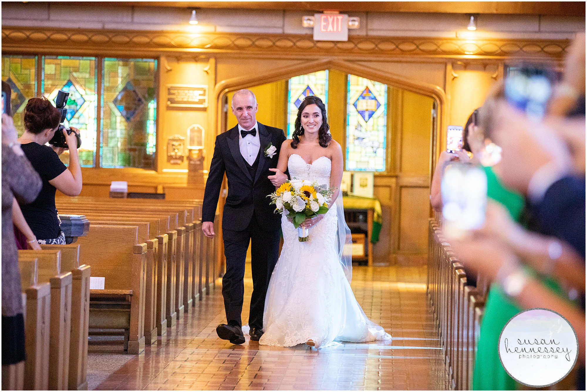bride walks down the aisle at ceremony at Saint Paul’s Roman Catholic Church in Princeton