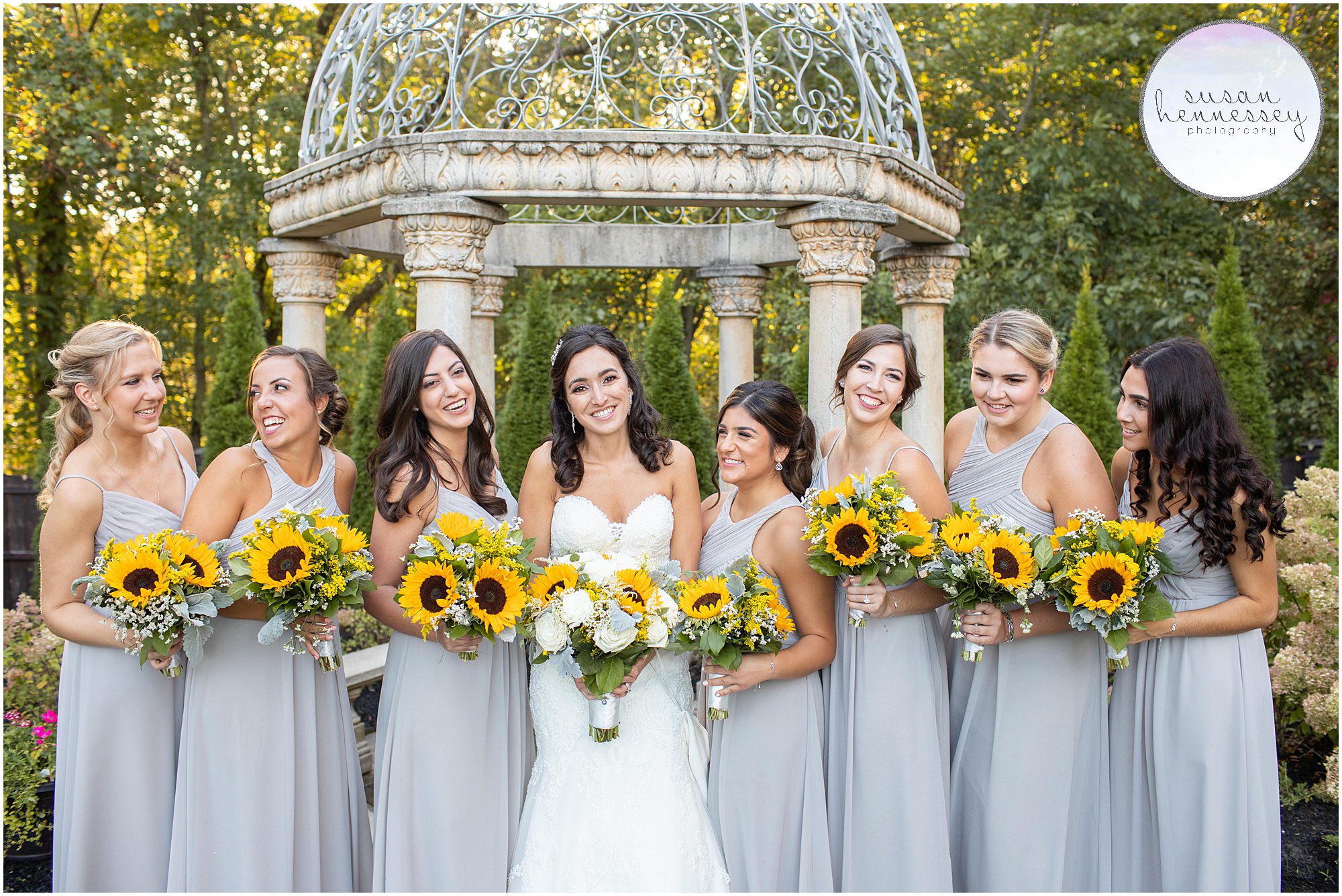 Bride and bridesmaids laugh with sunflower bouquets