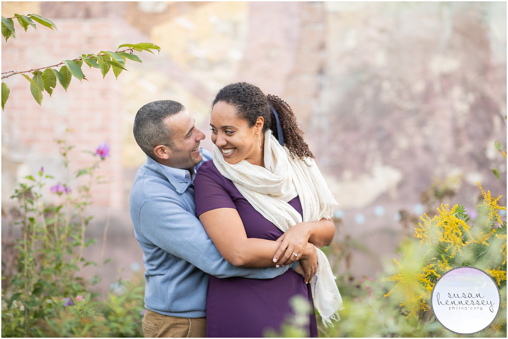 A couple pose in front of a colorful mural at their Philly engagement session