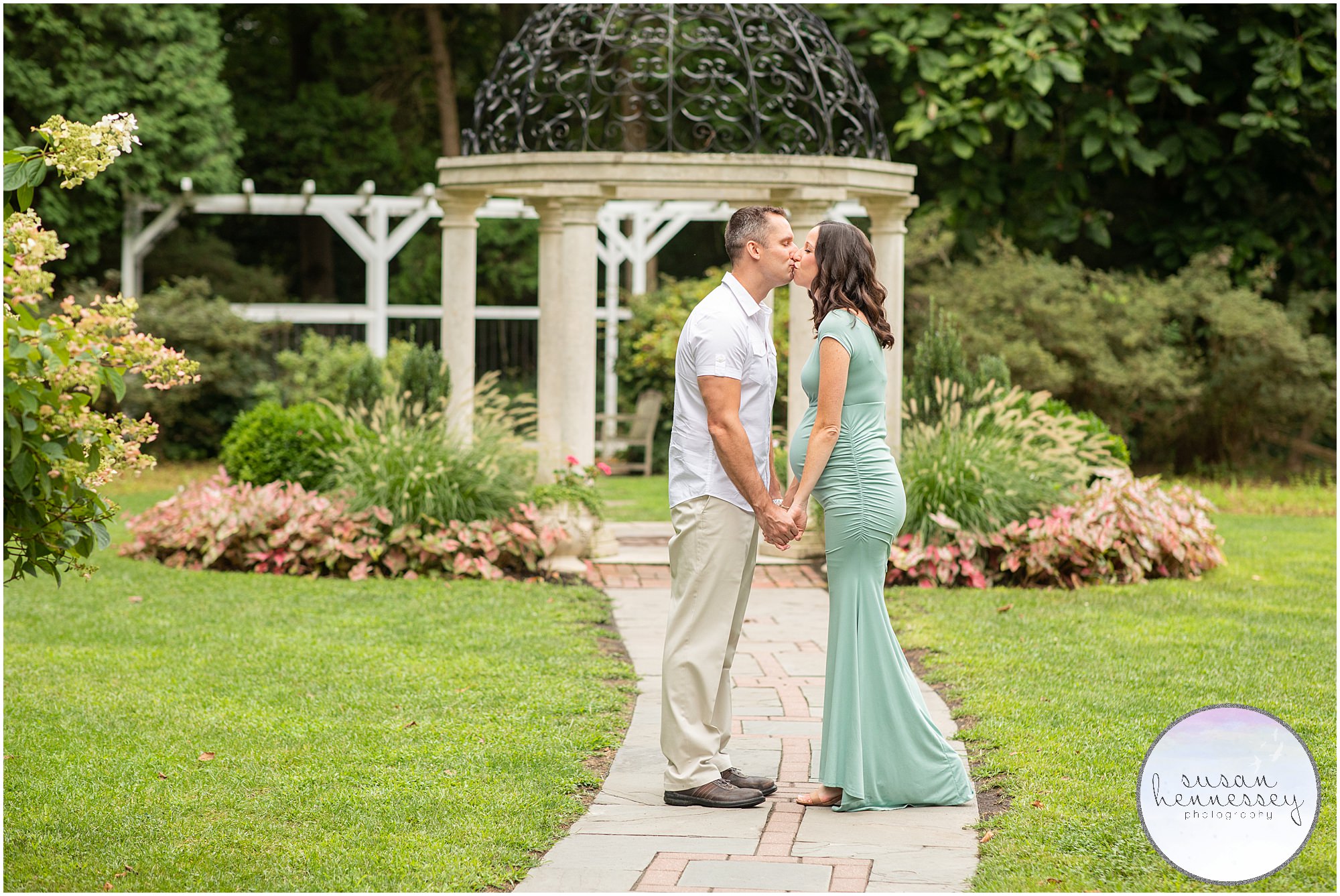 An expectant couple kiss at their maternity session