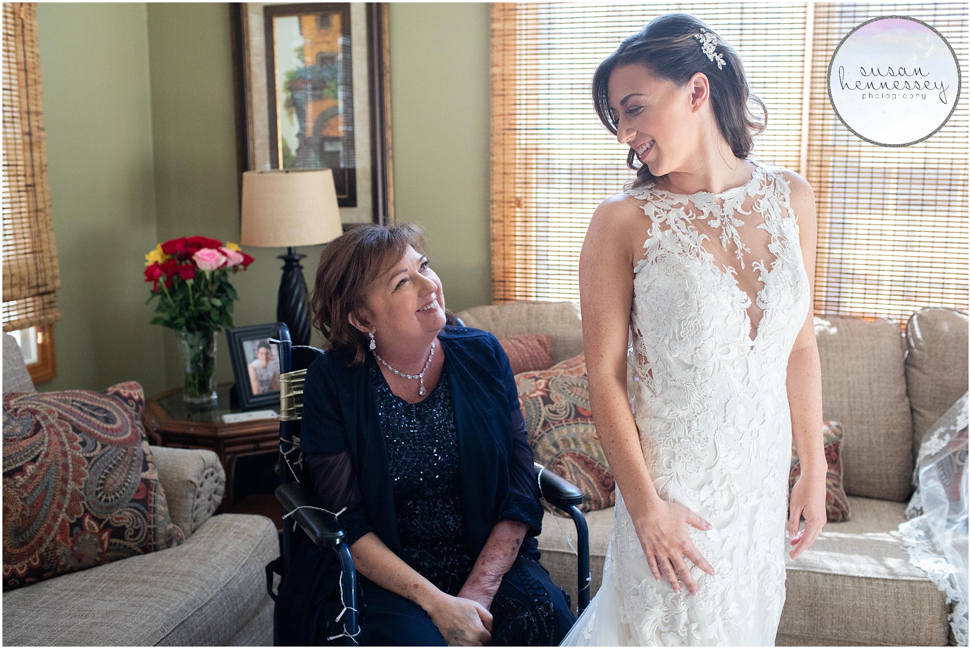 a bride's mother helps her into her Mori Lee wedding gown