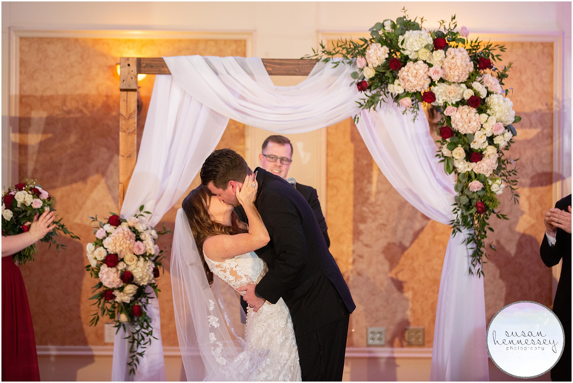 Bride and groom kiss at Indoor winter ceremony at the merion