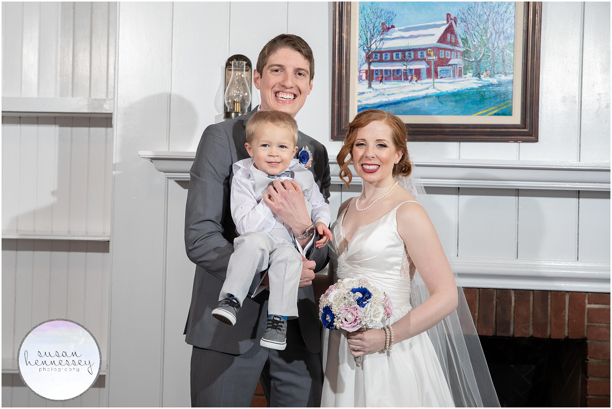 Bride and groom pose with adorable toddler