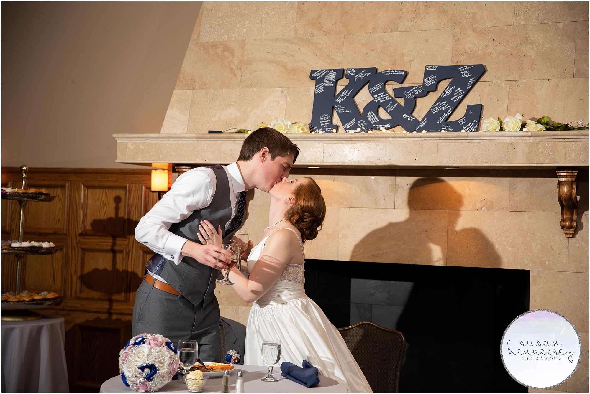 Bride and groom kiss at sweetheart table.