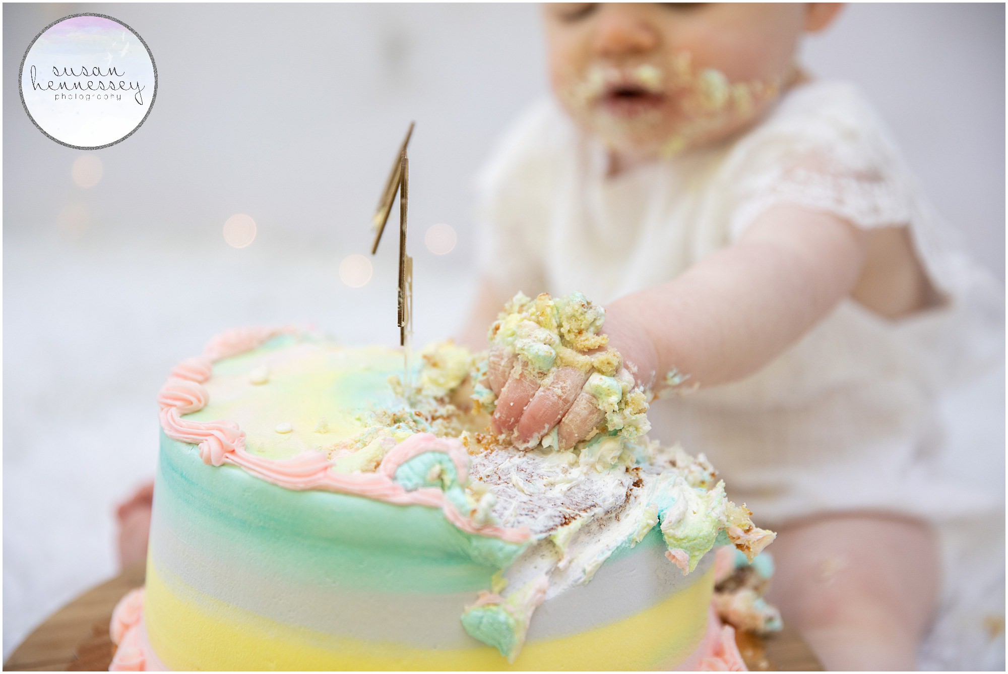Cake smash photgeraphy session featuring a rainbow backdrop