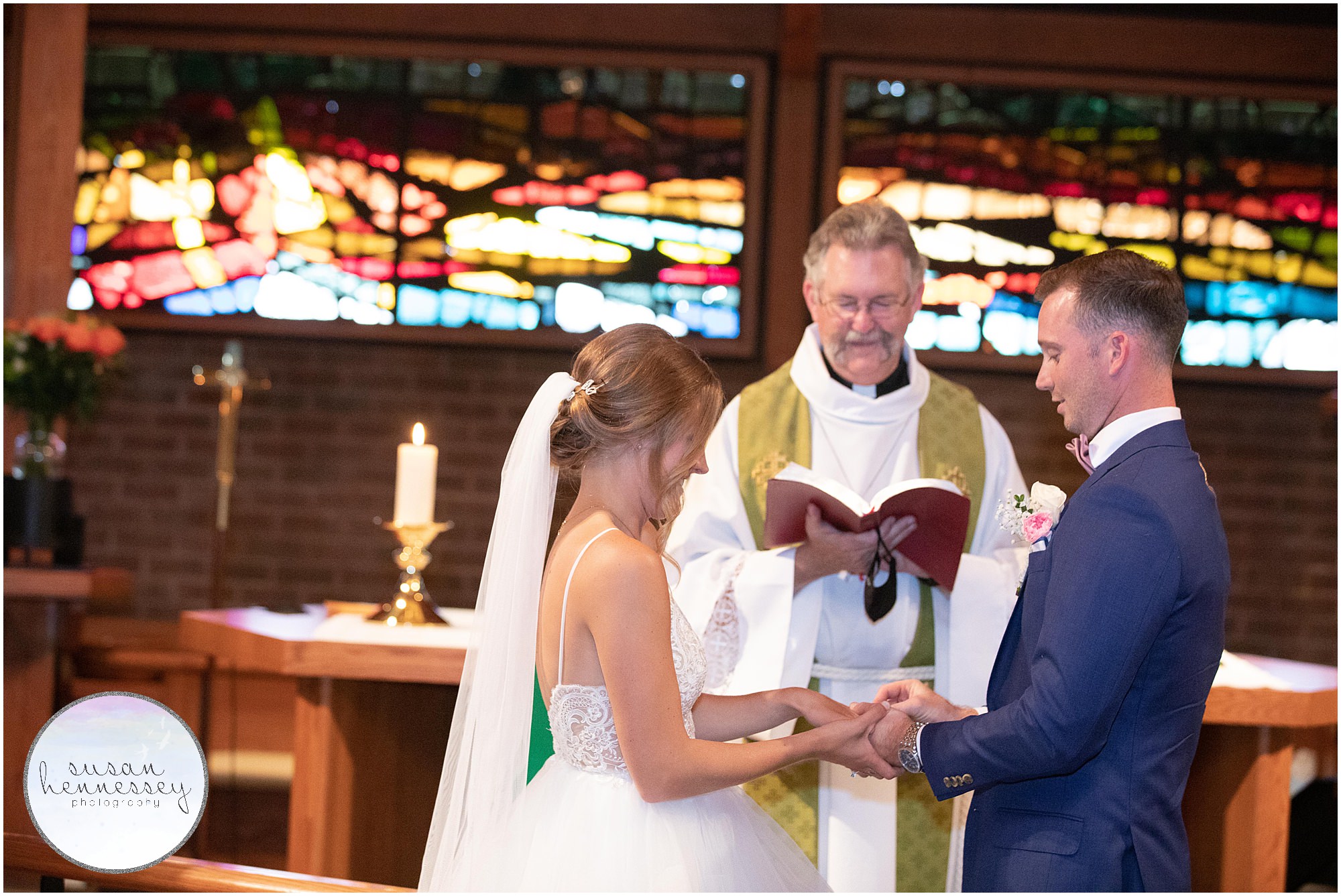 Groom places ring on bride's finger at church ceremony